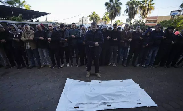 Palestinians pray before the funeral of a victim of an overnight Israeli strike, outside a hospital in Deir al-Balah, Gaza Strip, Wednesday, Dec. 4, 2024. (AP Photo/Abdel Kareem Hana)