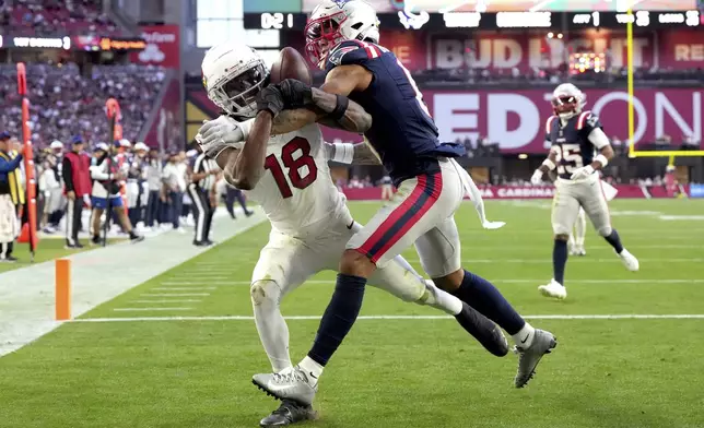 Arizona Cardinals wide receiver Marvin Harrison Jr. (18) can't make the catch as New England Patriots cornerback Christian Gonzalez (0) makes the hit during the first half of an NFL football game, Sunday, Dec. 15, 2024, in Glendale, Ariz. (AP Photo/Rick Scuteri)