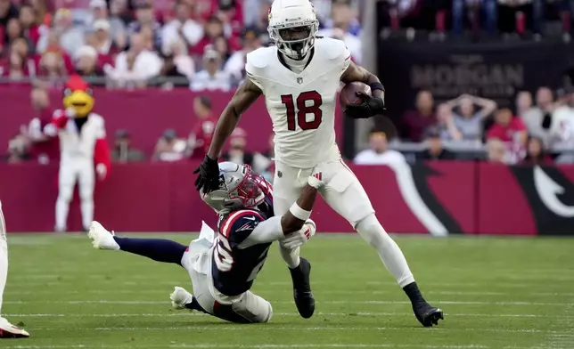 Arizona Cardinals wide receiver Marvin Harrison Jr. (18) runs after the catch as New England Patriots cornerback Marcus Jones defends during the first half of an NFL football game, Sunday, Dec. 15, 2024, in Glendale, Ariz. (AP Photo/Rick Scuteri)