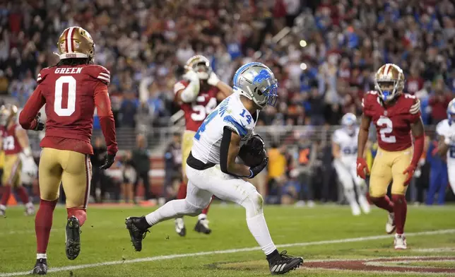 Detroit Lions wide receiver Amon-Ra St. Brown (14) catches a touchdown during the second half of an NFL football game against the San Francisco 49ers, Monday, Dec. 30, 2024, in Santa Clara, Calif. (AP Photo/Godofredo A. Vásquez)