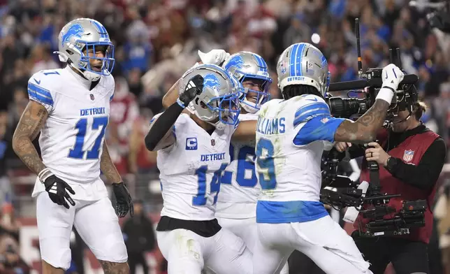 Detroit Lions wide receiver Amon-Ra St. Brown (14) celebrates his touchdown catch with teammate during the second half of an NFL football game Monday, Dec. 30, 2024, in Santa Clara, Calif. (AP Photo/Godofredo A. Vásquez)