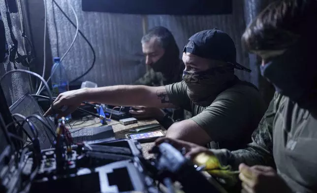 FILE- Ukrainian soldiers of 3rd assault brigade fly by an FPV exploding drone over Russian positions in Kharkiv region, Ukraine, on Aug. 24, 2024. (AP Photo/Evgeniy Maloletka, File)