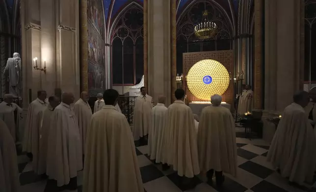 Clergymen and knights of the Equestrian Order of the Holy Sepulcher watch the ancient relic that many Christians revere as Jesus Christ's "Crown of Thorns" in Notre Dame Cathedral, five years after it was saved from the flames of the cathedral's devastating 2019 fire, Friday, Dec. 13, 2024 in Paris. (AP Photo/Aurelien Morissard)