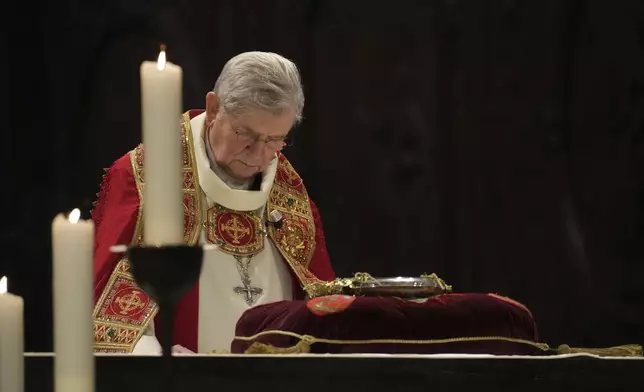 Paris Archbishop Laurent Ulrich leans at the ancient relic that many Christians revere as Jesus Christ's "Crown of Thorns" is returning to Notre Dame Cathedral, five years after it was saved from the flames of the cathedral's devastating 2019 fire, Friday, Dec. 13, 2024 in Paris. (AP Photo/Aurelien Morissard)