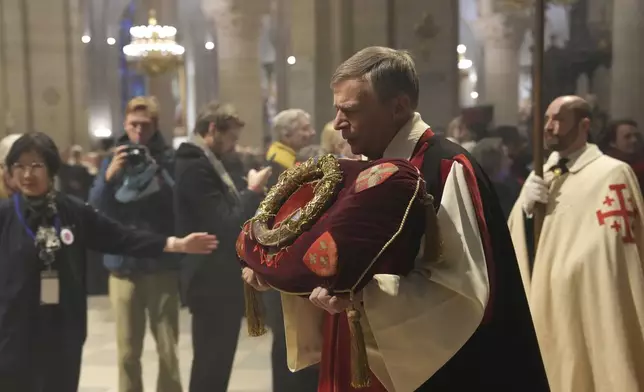 The ancient relic that many Christians revere as Jesus Christ's "Crown of Thorns" is presented during a procession as it is returning to Notre Dame Cathedral, five years after it was saved from the flames of the cathedral's devastating 2019 fire, Friday, Dec. 13, 2024 in Paris. (AP Photo/Aurelien Morissard)