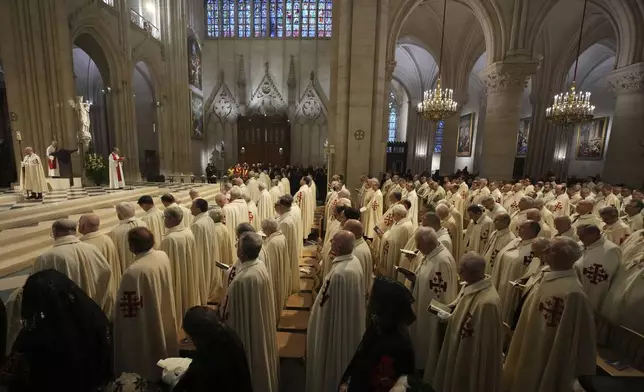Clergymen and Knights of the Equestrian Order of the Holy Sepulcher attend a ceremony as an ancient relic that many Christians revere as Jesus Christ's "Crown of Thorns" is returning to Notre Dame Cathedral, five years after it was saved from the flames of the cathedral's devastating 2019 fire, Friday, Dec. 13, 2024 in Paris. (AP Photo/Aurelien Morissard)