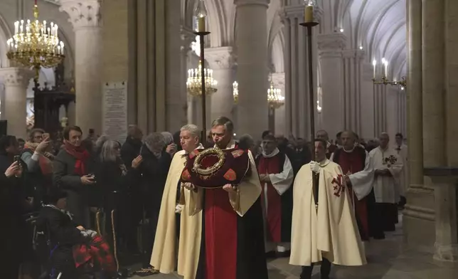 The ancient relic that many Christians revere as Jesus Christ's "Crown of Thorns" is presented during a procession as it is returning to Notre Dame Cathedral, five years after it was saved from the flames of the cathedral's devastating 2019 fire, Friday, Dec. 13, 2024 in Paris. (AP Photo/Aurelien Morissard)