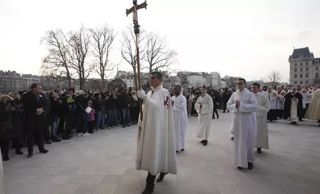 Clergymen arrive as an ancient relic that many Christians revere as Jesus Christ's "Crown of Thorns" is returning to Notre Dame Cathedral, five years after it was saved from the flames of the cathedral's devastating 2019 fire, Friday, Dec. 13, 2024 in Paris. (AP Photo/Aurelien Morissard)