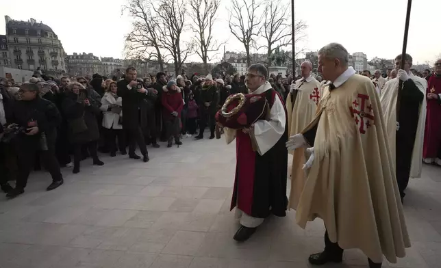 Knights of the Equestrian Order of the Holy Sepulcher arrive with the "Crown of Thorns" as the ancient relic that many Christians revere as Jesus Christ's "Crown of Thorns" is returning to Notre Dame Cathedral, five years after it was saved from the flames of the cathedral's devastating 2019 fire, Friday, Dec. 13, 2024 in Paris. (AP Photo/Aurelien Morissard)