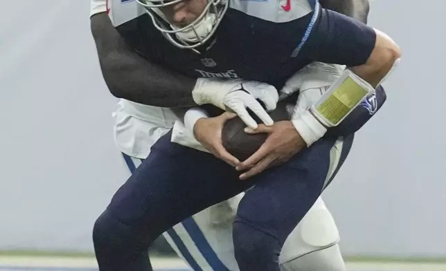 Tennessee Titans quarterback Mason Rudolph (11) is sacked by Indianapolis Colts defensive end Kwity Paye (51) during the second half of an NFL football game Sunday, Dec. 22, 2024, in Indianapolis. (AP Photo/Darron Cummings)