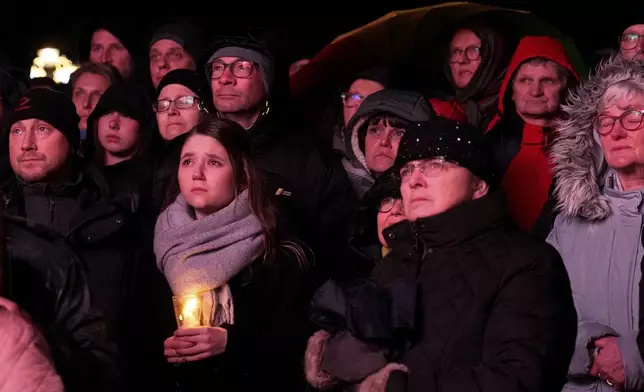 People outside Magdeburg Cathedral follow a memorial service for victims of Friday's Christmas Market attack, where a car drove into a crowd, in Magdeburg, Germany, Saturday, Dec. 21, 2024. (AP Photo/Ebrahim Noroozi)