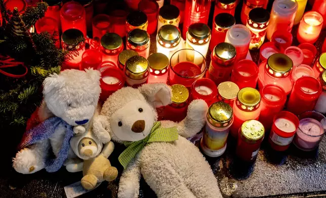 Teddy bears were laid together with candles near the Christmas market, where a car drove into a crowd on Friday evening, in Magdeburg, Germany, Sunday, Dec. 22, 2024. (AP Photo/Michael Probst)