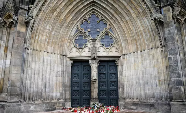 Flowers and candles laid down in front of the Magdeburg Cathedra, after a car drove into a crowd of a Christmas Mark on Friday evening, in Magdeburg, Germany, Sunday, Dec. 22, 2024. (AP Photo/Ebrahim Noroozi)