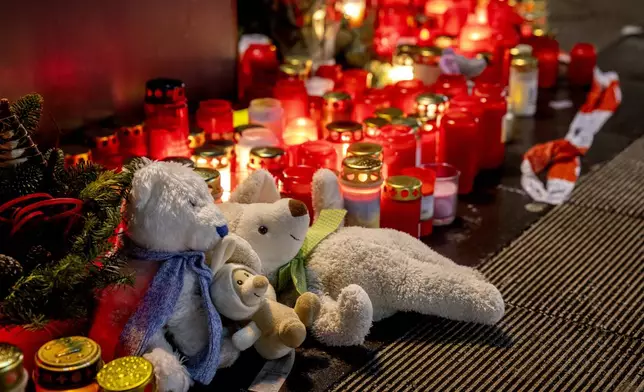 Teddy bears were laid together with candles near the Christmas market, where a car drove into a crowd on Friday evening, in Magdeburg, Germany, Sunday, Dec. 22, 2024. (AP Photo/Michael Probst)