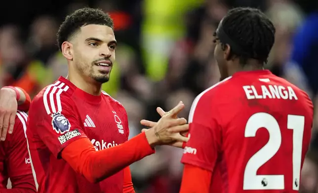 Nottingham Forest's Morgan Gibbs-White, left, celebrates scoring their side's second goal during the English Premier League soccer match between Everton and Nottingham Forest at Goodison Park, Liverpool, England, Sunday, Dec. 29, 2024. (Peter Byrne/PA via AP)