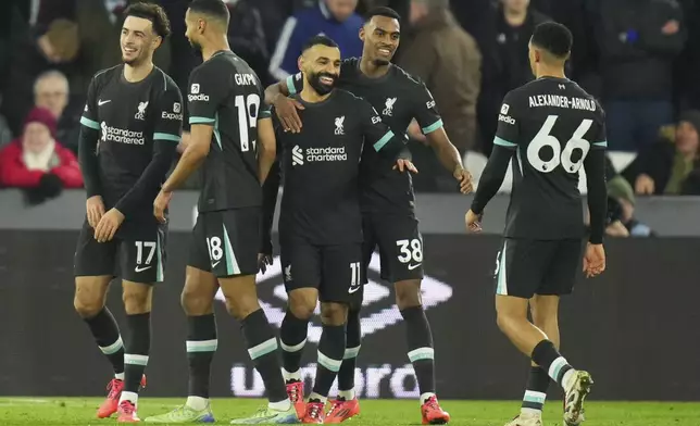 Liverpool's Mohamed Salah, center, celebrates with teammates after scoring his side's third goal during the English Premier League soccer match between West Ham United and Liverpool at the London Stadium in London, Sunday, Dec. 29, 2024. (AP Photo/Kirsty Wigglesworth)