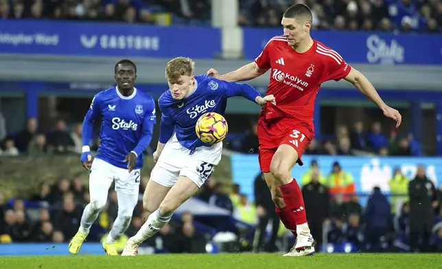 Everton's Jarrad Branthwaite, centre, and Nottingham Forest's Nikola Milenkovic battle for the ball during the English Premier League soccer match between Everton and Nottingham Forest at Goodison Park, Liverpool, England, Sunday, Dec. 29, 2024. (Peter Byrne/PA via AP)