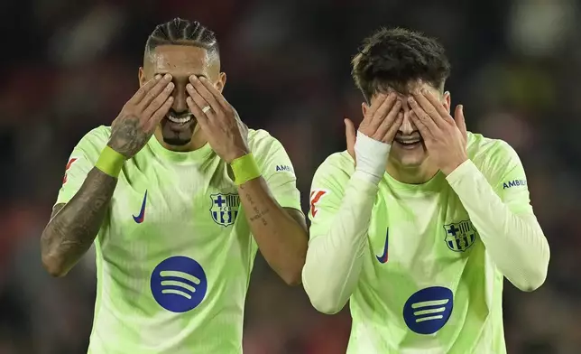 Barcelona's Pau Victor, right, celebrates with Raphinha after scoring his side's fifth goal during a Spanish La Liga soccer match between Mallorca and Barcelona at the Son Moix stadium in Palma de Mallorca, Spain, Tuesday, Dec. 3, 2024. (AP Photo/Jose Breton)