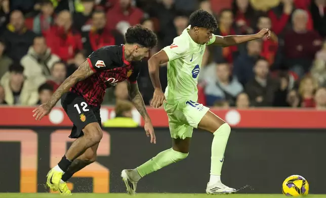 Mallorca's Samu Costa, left, challenges for the ball with Barcelona's Lamine Yamal during a Spanish La Liga soccer match between Mallorca and Barcelona at the Son Moix stadium in Palma de Mallorca, Spain, Tuesday, Dec. 3, 2024. (AP Photo/Jose Breton)