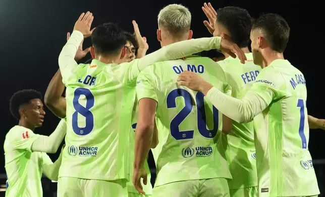 Barcelona players celebrate after Ferran Torres scored the opening goal during a Spanish La Liga soccer match between Mallorca and Barcelona at the Son Moix stadium in Palma de Mallorca, Spain, Tuesday, Dec. 3, 2024. (AP Photo/Jose Breton)