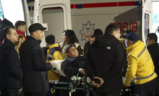 Rescuers transport wounded passengers from a medical plane after the Azerbaijani Airline crashed, near the Kazakhstani city of Aktau, upon their arrival at the Heydar Aliyev International Airport outside Baku, Azerbaijan, Thursday, Dec. 26, 2024. (AP Photo)