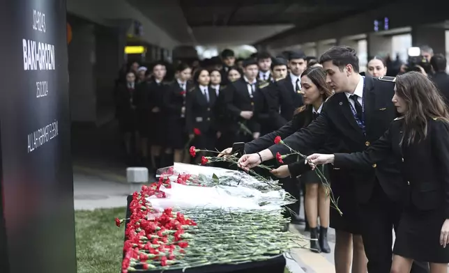 Cadets of the aviation school lay flowers in memory of victims of the Azerbaijan Airlines' Embraer 190 that crashed near the Kazakhstan's airport of Aktau, at the Heydar Aliyev International Airport outside Baku, Azerbaijan, Thursday, Dec. 26, 2024. (AP Photo)