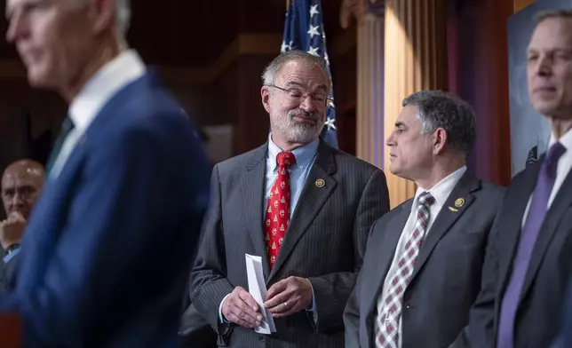 Rep. Andy Harris, R-Md., chairman of the House Freedom Caucus, center left, speaks with Rep. Andrew Clyde, R-Ga., center right, as they join a group of conservative Republicans to talk about the interim spending bill being crafted to avoid a shutdown of federal agencies, at the Capitol in Washington, Wednesday, Dec. 18, 2024. (AP Photo/J. Scott Applewhite)