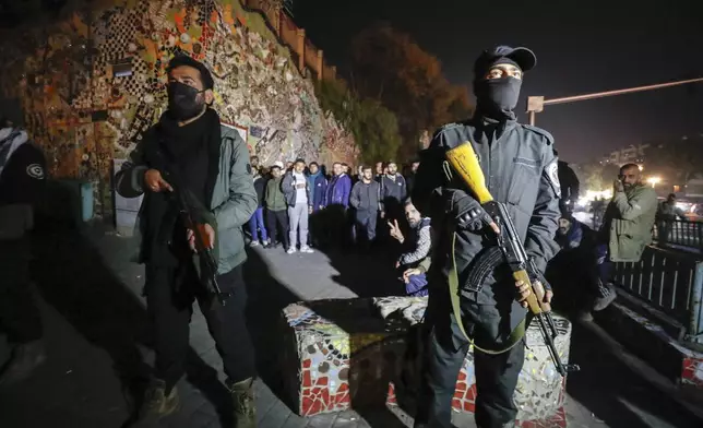 Security forces of the new Syrian government secure the area around group of Alawite protesters in the Mazzeh district in Damascus Wednesday Dec. 25, 2024. The minority Alawite community is an offshoot of Shiite Islam that form President Bashar Assad belongs to. (AP Photo/Omar Sanadiki)