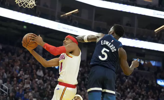 Golden State Warriors guard Moses Moody (4) drives to the basket against Minnesota Timberwolves guard Anthony Edwards (5) during the first half of an NBA basketball game in San Francisco, Sunday, Dec. 8, 2024. (AP Photo/Tony Avelar)