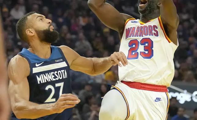 Golden State Warriors forward Draymond Green (23) shoots over Minnesota Timberwolves center Rudy Gobert (27) during the first half of an NBA basketball game in San Francisco, Sunday, Dec. 8, 2024. (AP Photo/Tony Avelar)