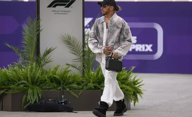 Mercedes driver Lewis Hamilton of Britain walks through paddock as he arrives at the Lusail International Circuit in Lusail, Qatar, ahead of the Qatar Grand Prix, Thursday, Nov. 28, 2024. (AP Photo/Darko Bandic)