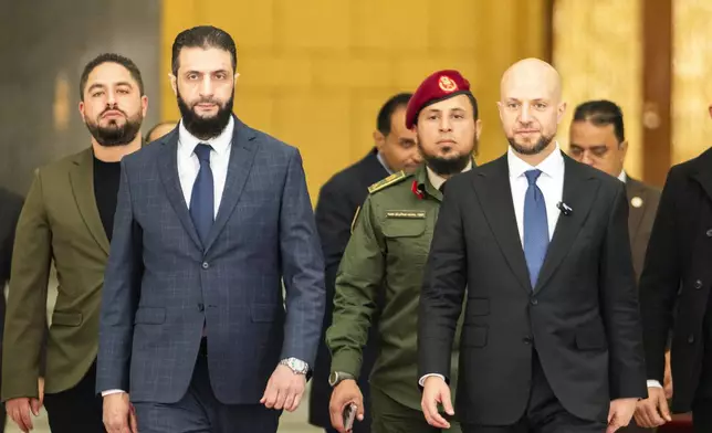 Syria's de facto leader Ahmad al-Sharaa, oreground left, formerly known as Abu Mohammed al-Golani, meets with Walid Ellafi, right, Libyan minister of state for communication and political affairs, in the presidential palace in Damascus, Syria, Saturday, Dec. 28, 2024. (AP Photo/Mosa'ab Elshamy)