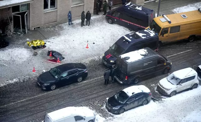 Investigators stand at the site where Lt. Gen. Igor Kirillov, the head of Russia's Nuclear, Biological, and Chemical Defense Forces, and his assistant, Ilya Polikarpov, were killed by an explosive device planted close to a residential apartment's block in Moscow, Russia, Tuesday, Dec. 17, 2024. (AP Photo)