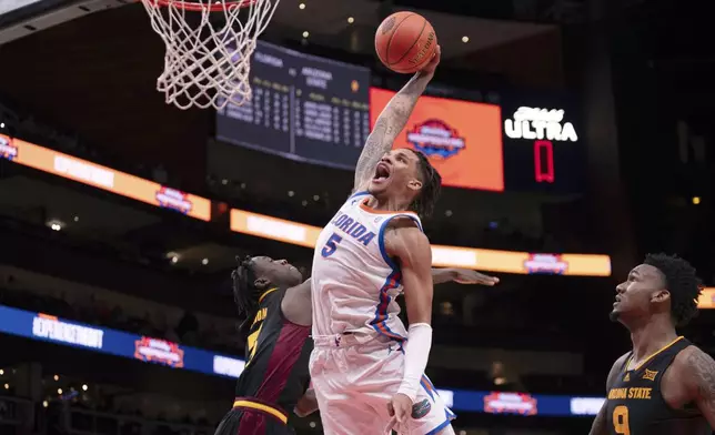 Florida guard Will Richard (5) dunks the ball over Arizona State guard Joson Sanon (3) during the second half of an NCAA college basketball game against Arizona State on Saturday, Dec. 14, 2024, in Atlanta. (AP Photo/Kathryn Skeean)