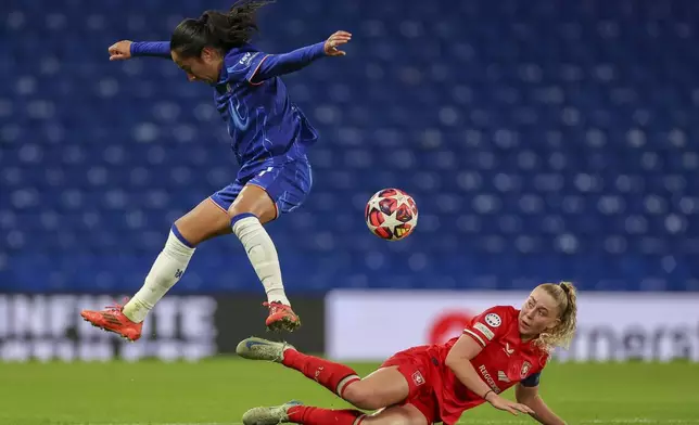 Chelsea's Mayra Ramirez, left, is challenged by Twente's Danique van Ginkel during the Women's Champions League group B soccer match at Stamford Bridge stadium in London, Wednesday, Dec. 11, 2024. (AP Photo/Ian Walton)