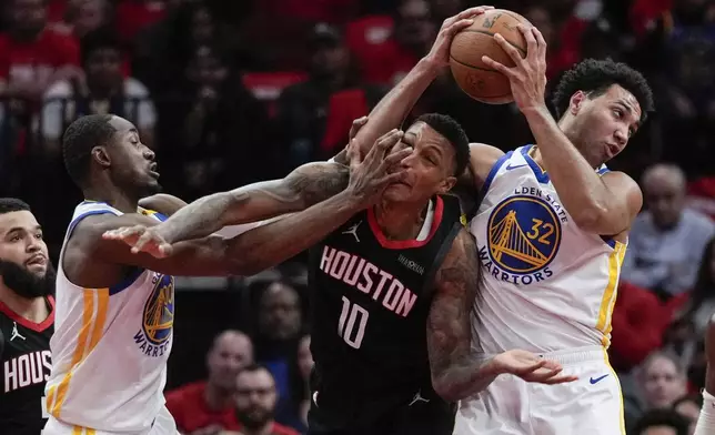 Golden State Warriors forward Jonathan Kuminga (00), forward Trayce Jackson-Davis (32), and Houston Rockets forward Jabari Smith Jr. (10) vie for the ball during the first half of an Emirates NBA cup tournament quarterfinal basketball game in Houston, Wednesday, Dec. 11, 2024. (AP Photo/Ashley Landis)