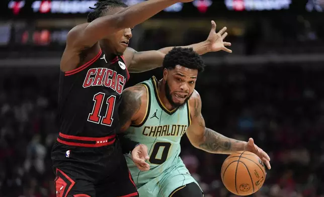 Chicago Bulls guard Ayo Dosunmu, left, guards Charlotte Hornets forward Miles Bridges during the first half of an NBA basketball game Friday, Dec. 13, 2024, in Chicago. (AP Photo/Erin Hooley)