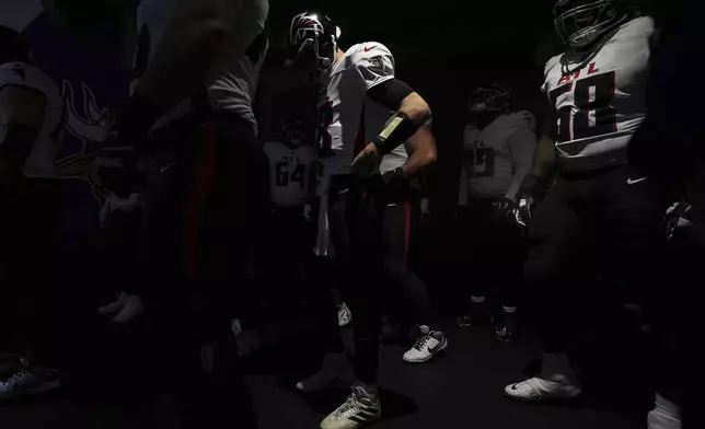 Atlanta Falcons quarterback Kirk Cousins, center, waits in the tunnel before an NFL football game against the Minnesota Vikings, Sunday, Dec. 8, 2024, in Minneapolis. (AP Photo/Abbie Parr)