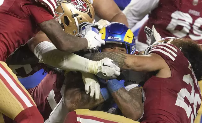 Los Angeles Rams running back Kyren Williams, middle, is tackled against the San Francisco 49ers during the second half of an NFL football game in Santa Clara, Calif., Thursday, Dec. 12, 2024. (AP Photo/Godofredo A. Vásquez)