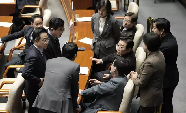 South Korea's main opposition Democratic Party leader Lee Jae-myung, third from right, talks with his party members during the plenary session at the National Assembly in Seoul, South Korea, Thursday, Dec. 26, 2024. (AP Photo/Ahn Young-joon)