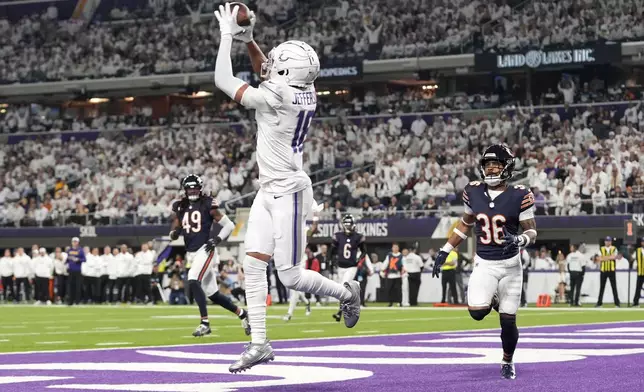 Minnesota Vikings wide receiver Justin Jefferson (18) catches a 7-yard touchdown pass in front of Chicago Bears safety Jonathan Owens (36) during the first half of an NFL football game, Monday, Dec. 16, 2024, in Minneapolis. (AP Photo/Abbie Parr)