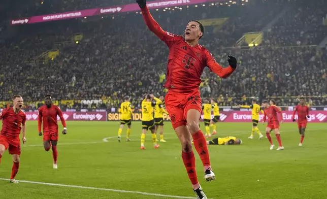 Bayern's Jamal Musiala celebrates after scoring during the German Bundesliga soccer match between Borussia Dortmund and Bayern Munich at the Signal-Iduna Park in Dortmund, Germany, Saturday, Nov. 30, 2024. (AP Photo/Martin Meissner)