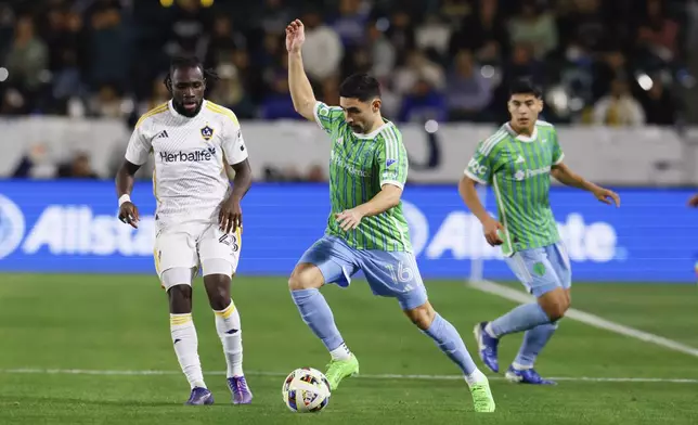 Seattle Sounders midfielder Alex Roldan (16) controls the ball next to Los Angeles Galaxy forward Joseph Paintsil (28) during the second half of an MLS Western Conference final soccer match, Saturday, Nov. 30, 2024, in Carson, Calif. (AP Photo/Etienne Laurent)