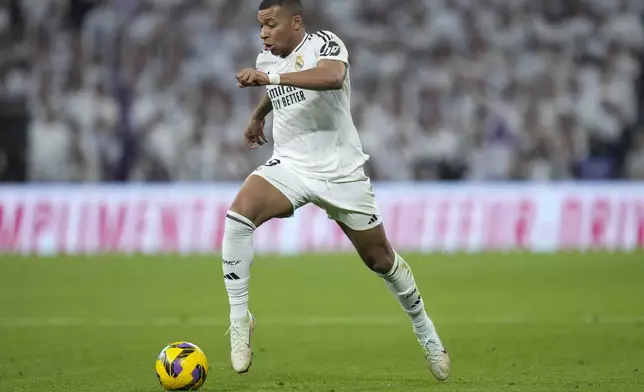 Real Madrid's Kylian Mbappe takes control of the ball during the Spanish La Liga soccer match between Real Madrid and Getafe at the Santiago Bernabeu Stadium in Madrid, Spain, Sunday, Dec. 1, 2024. (AP Photo/Bernat Armangue)