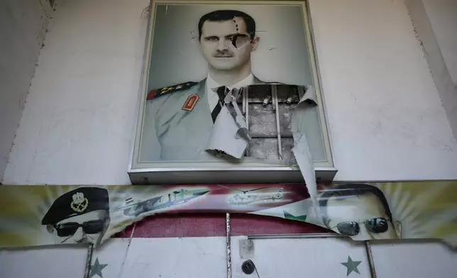 FILE.- A torn posters shows the late Syrian President Hafez Assad and his son the ousted Syrian president Bashar Assad, that were set at the entrance of the notorious security detention centre called Palestine Branch, in Damascus, Syria, Saturday, Dec. 14, 2024. (AP Photo/Hussein Malla,File)