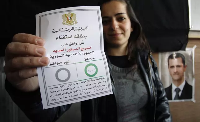 FILE PHOTO.- A Syrian woman shows her ballot paper at a polling station during a referendum on the new constitution aimed at quelling the country's uprising by ending the ruling Baath Party's five-decade domination of power, in Damascus, Syria, Sunday, Feb. 26, 2012. (AP Photo/Muzaffar Salman,File)