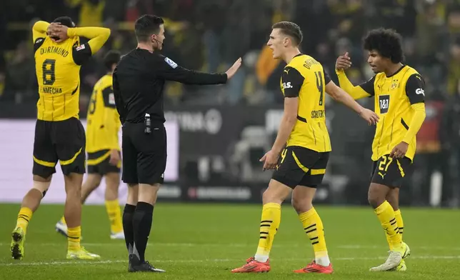 Dortmund's Karim Adeyemi, right, reacts after receiving a yellow card during the German Bundesliga soccer match between Borussia Dortmund and TSG Hoffenheim at the Signal-Iduna Park in Dortmund, Germany, Sunday, Dec. 15 2024. (AP Photo/Martin Meissner)