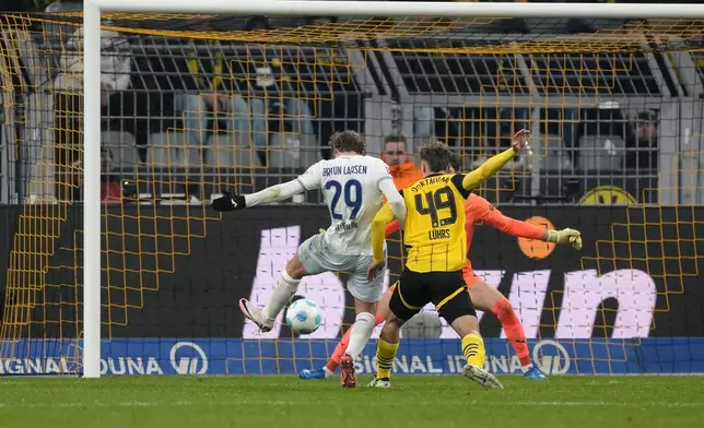 Hoffenheim's Jacob Bruun Larsen, left, scores his side's first goal during the German Bundesliga soccer match between Borussia Dortmund and TSG Hoffenheim at the Signal-Iduna Park in Dortmund, Germany, Sunday, Dec. 15 2024. (AP Photo/Martin Meissner)