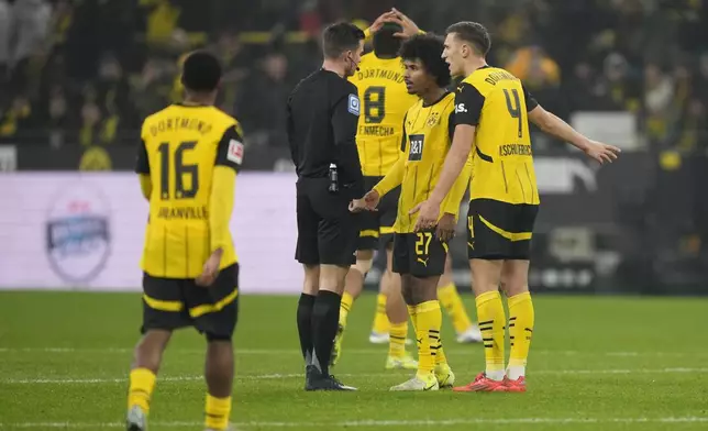 Dortmund's Karim Adeyemi, second right, argues with the referee after receiving a yellow card during the German Bundesliga soccer match between Borussia Dortmund and TSG Hoffenheim at the Signal-Iduna Park in Dortmund, Germany, Sunday, Dec. 15 2024. (AP Photo/Martin Meissner)