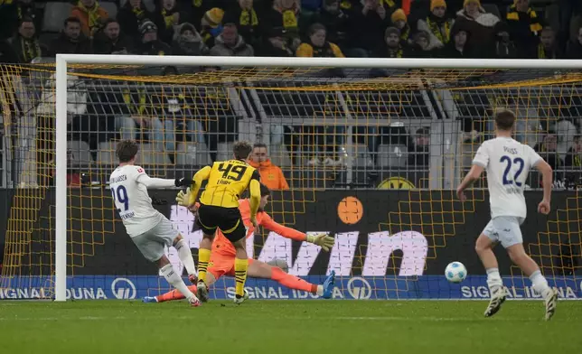 Hoffenheim's Jacob Bruun Larsen, left, scores his side's first goal during the German Bundesliga soccer match between Borussia Dortmund and TSG Hoffenheim at the Signal-Iduna Park in Dortmund, Germany, Sunday, Dec. 15 2024. (AP Photo/Martin Meissner)